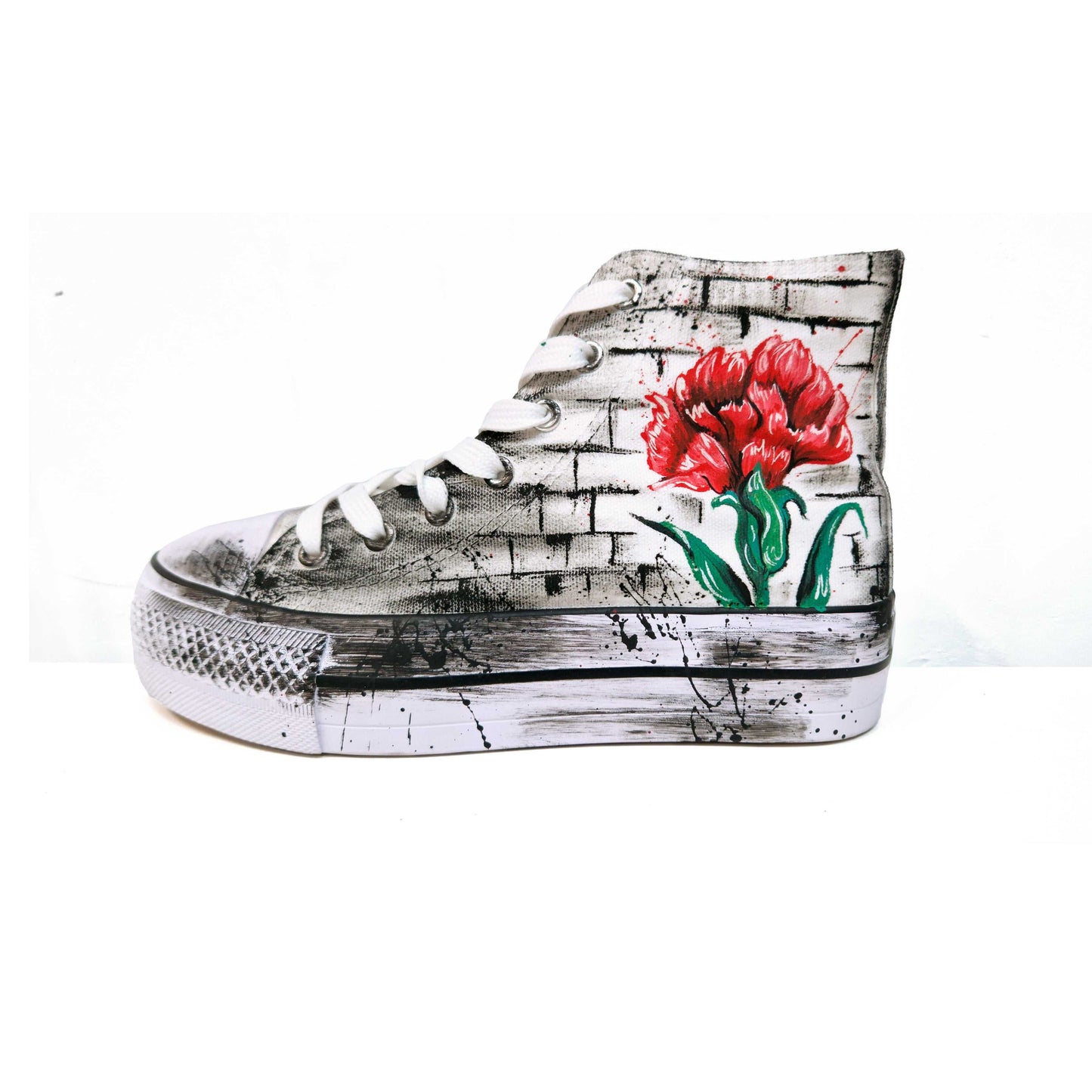 Zapatillas de tela pintadas a mano, de plataforma, con diseño de claveles rojos y la palabra "Madrid" en rojo. Fondo difuminado en gris con salpicaduras de pintura negra.