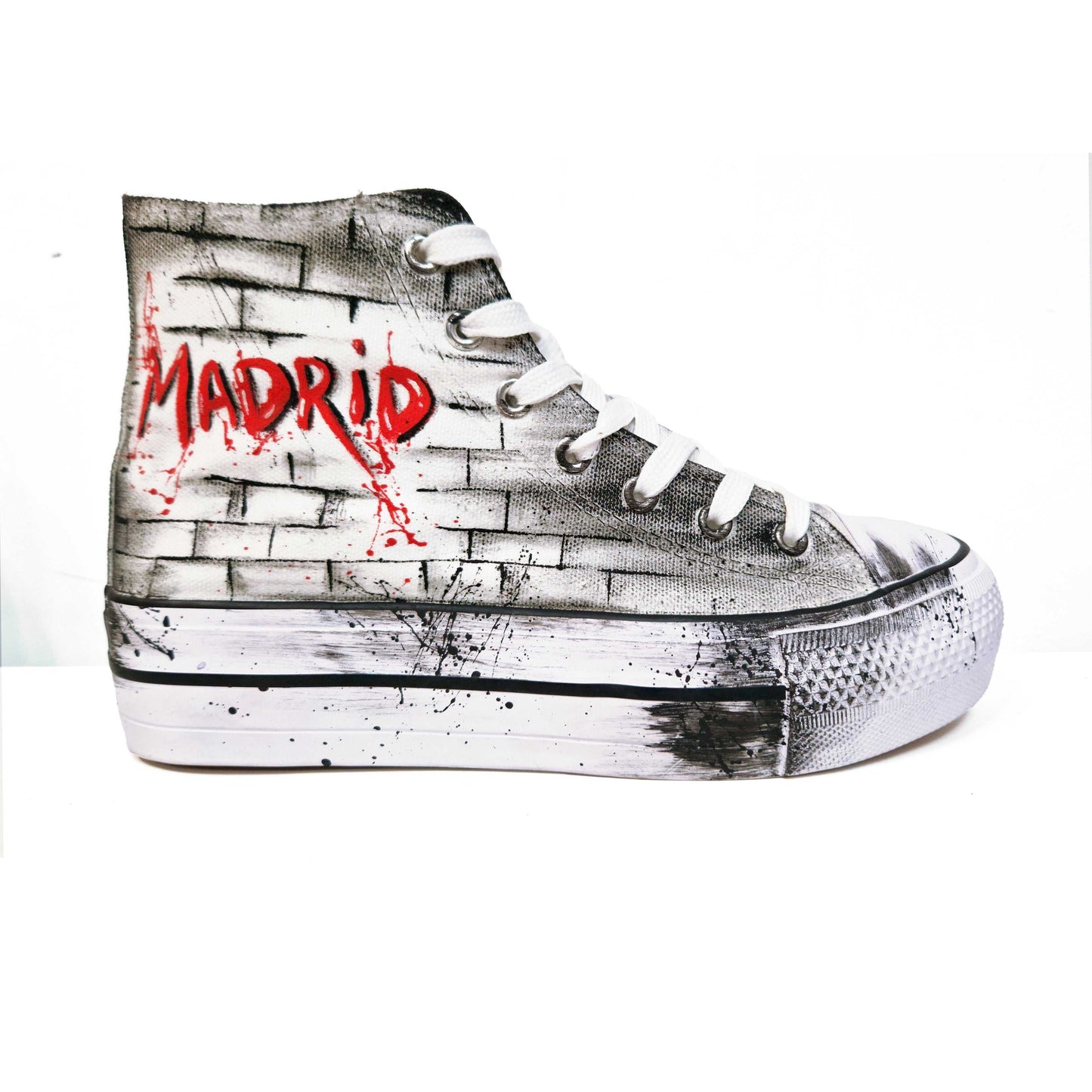 Zapatillas de tela pintadas a mano, de plataforma, con diseño de claveles rojos y la palabra "Madrid" en rojo. Fondo difuminado en gris con salpicaduras de pintura negra.