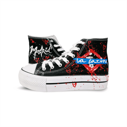 Zapatilla de tela  pintada a mano con fondo en negro, con diseño de metropolitana de madrid  y  salpicaduras en rojo. Cordones blancos