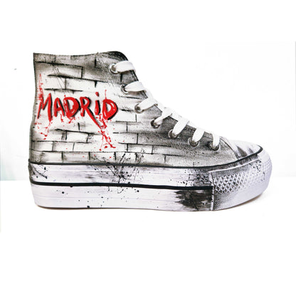 Zapatillas de tela pintadas a mano, de plataforma, con diseño de claveles rojos y la palabra "Madrid" en rojo. Fondo difuminado en gris con salpicaduras de pintura negra.